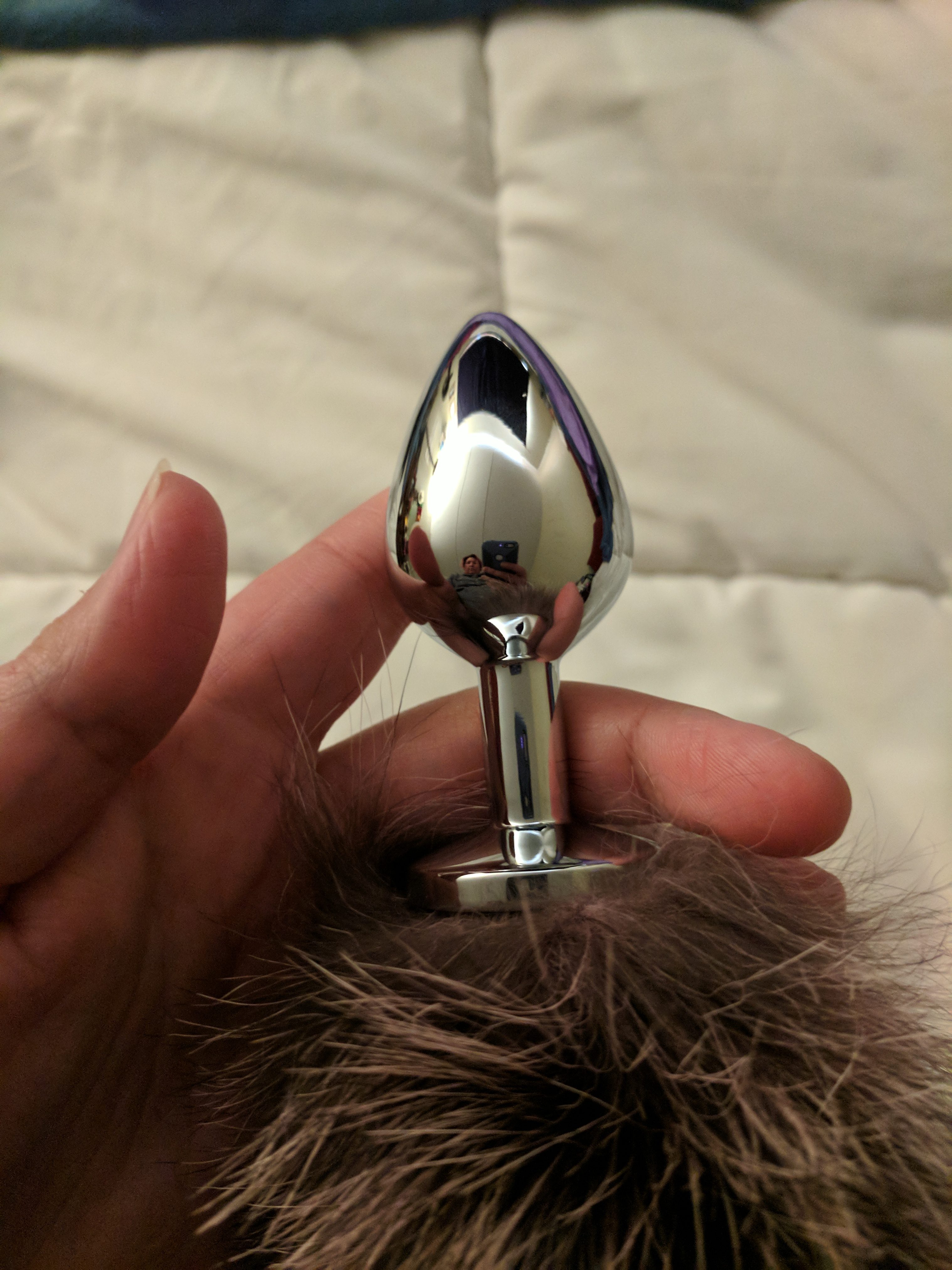 Stainless steel plug in hand, showing shape and size