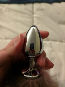 Stainless steel plug in hand, but closer, showing its size more clearly