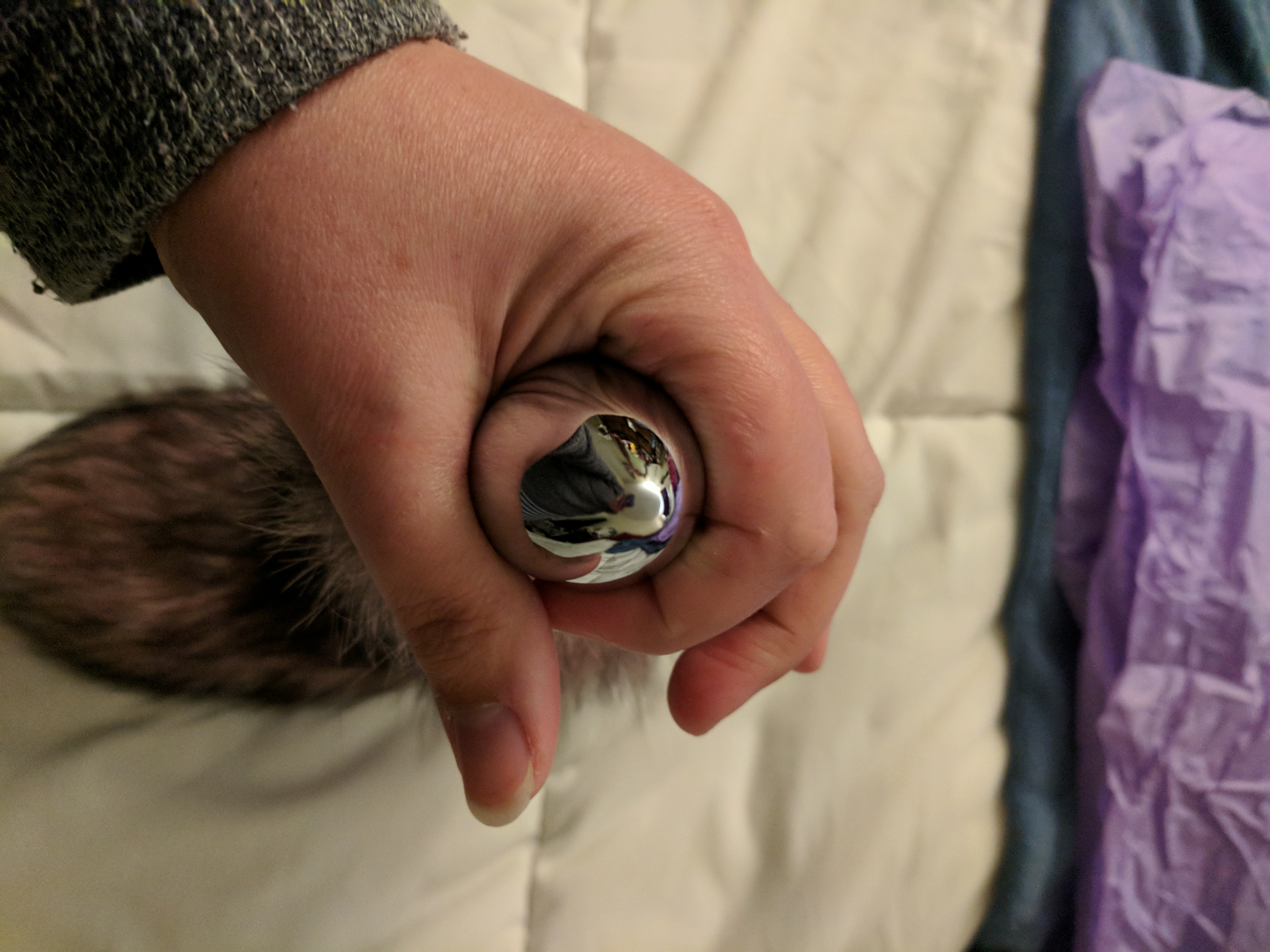 Plug in hand, with fingers wrapped around it for scale
