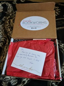 Inside the box, there's a Bawdy Bookworms sticker adorning the inside lid, and then a personalized note to me on top of some red tissue paper.