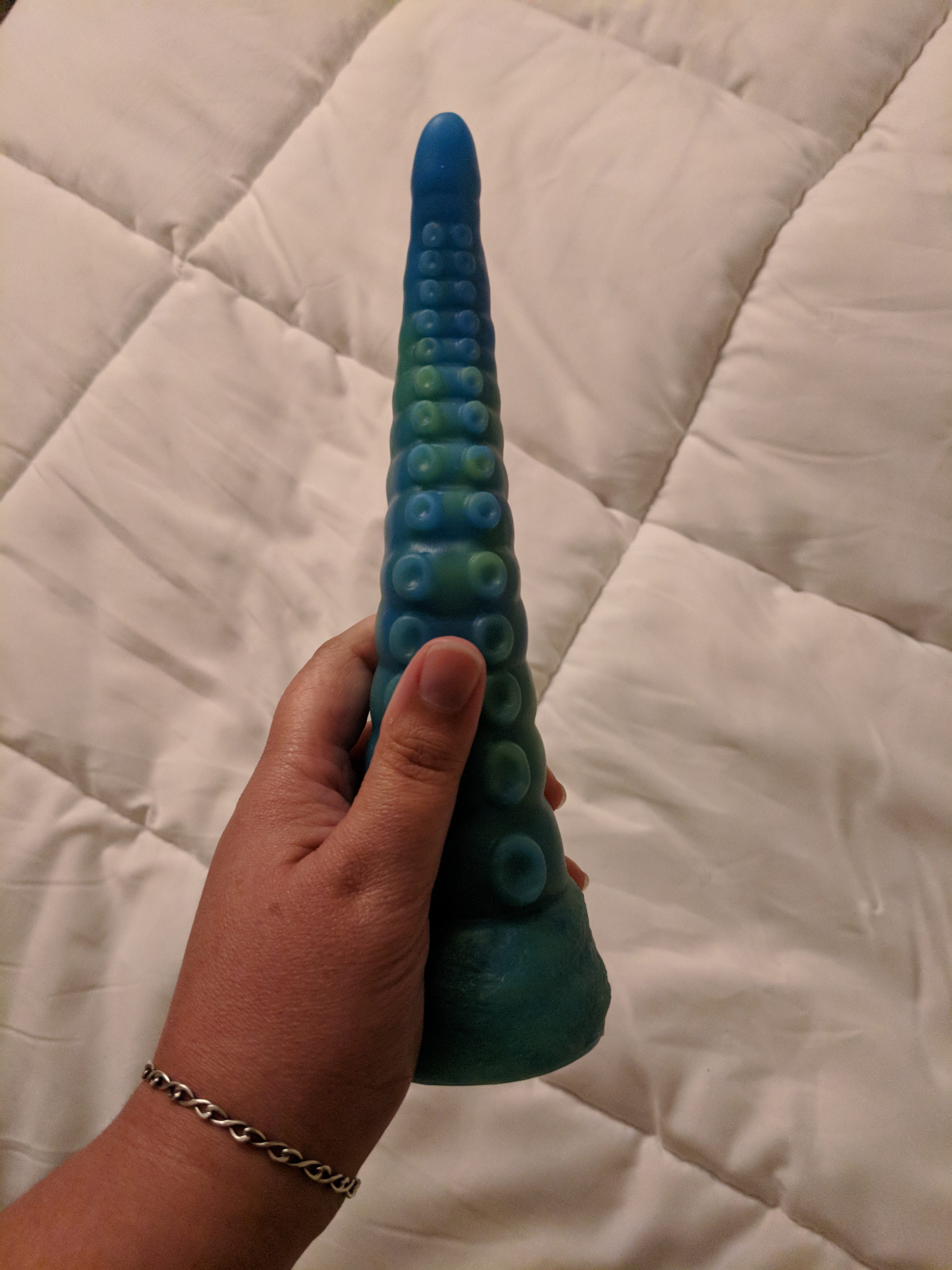 Tentacle dildo in hand, pictured suction cups up